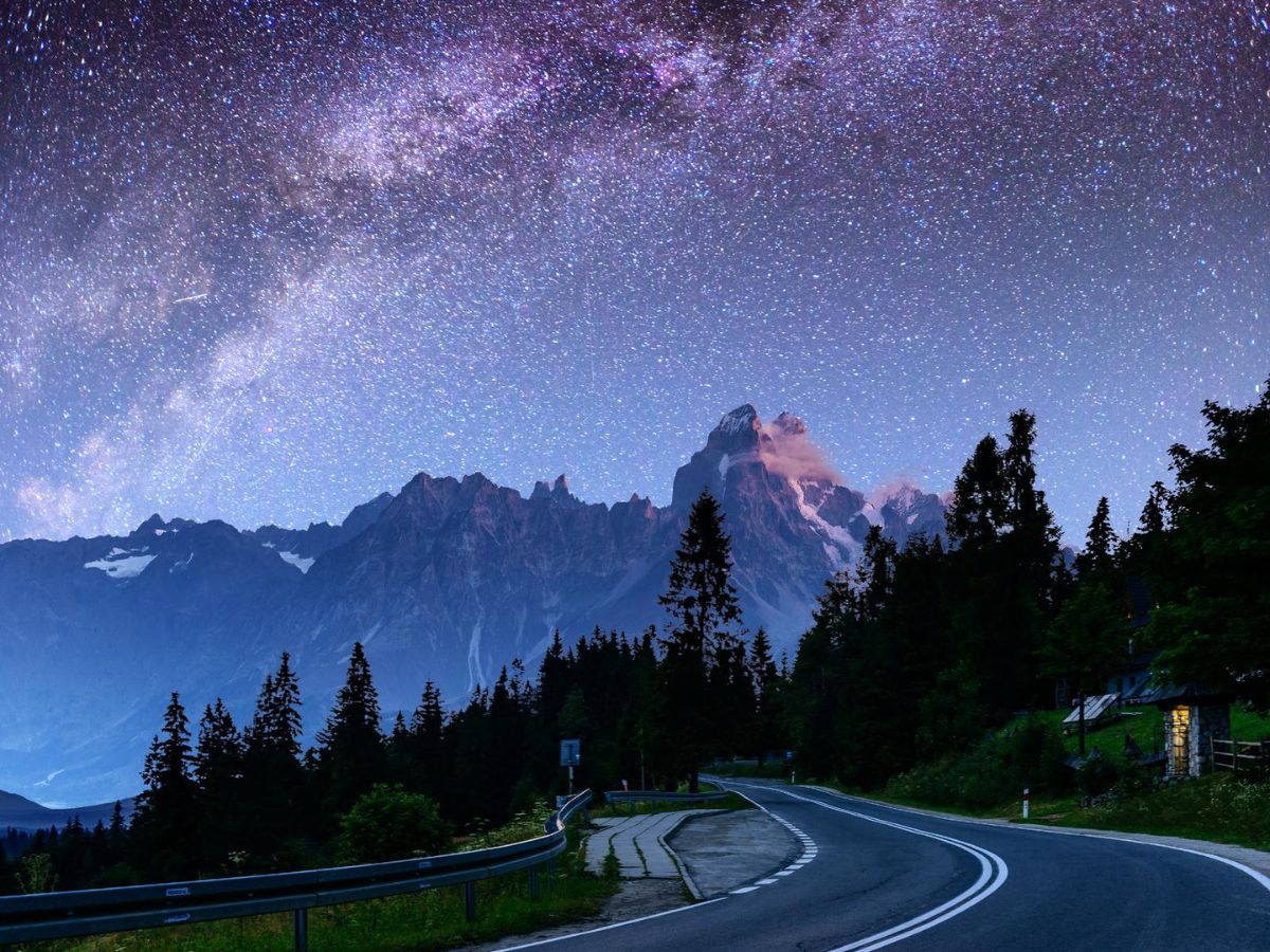 The milky over a mountain road with mountains in the background.