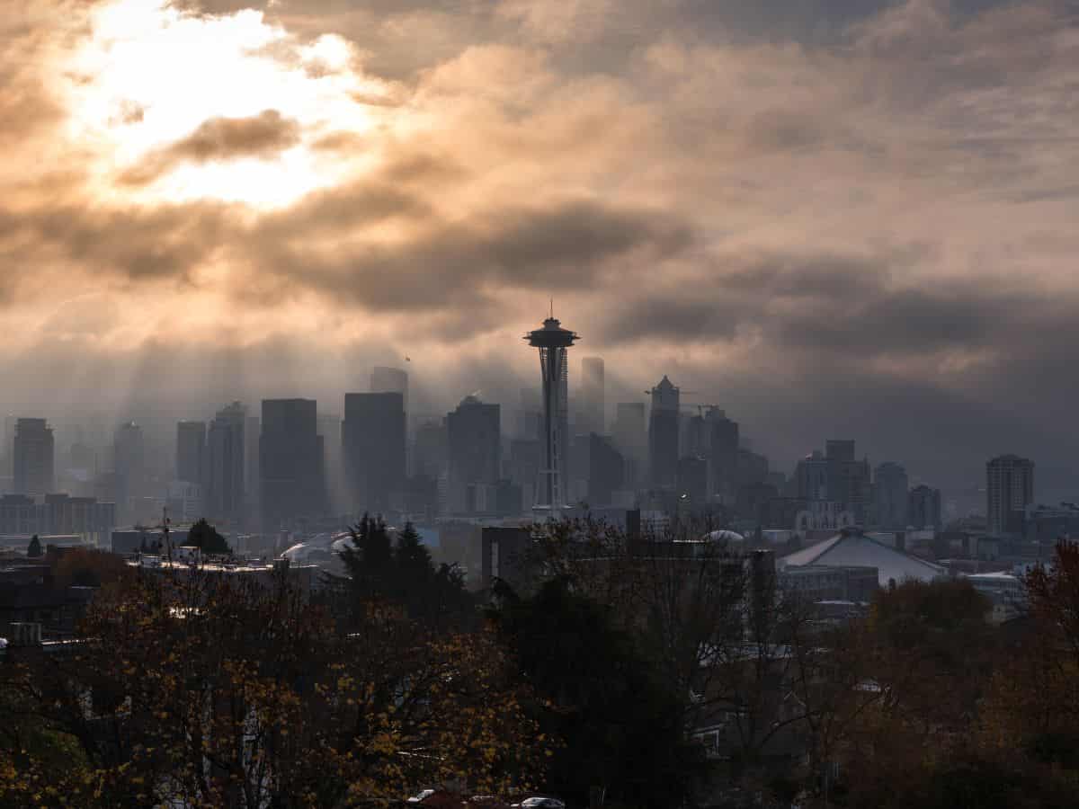 A sunbeam shines over the seattle skyline on a cloudy day.