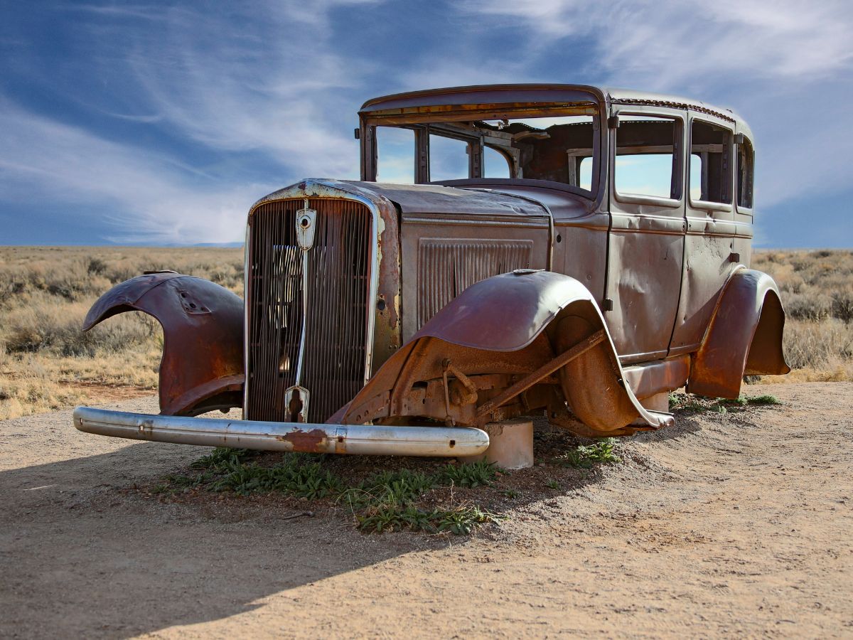 An old rusted car in the desert along old Route 66.