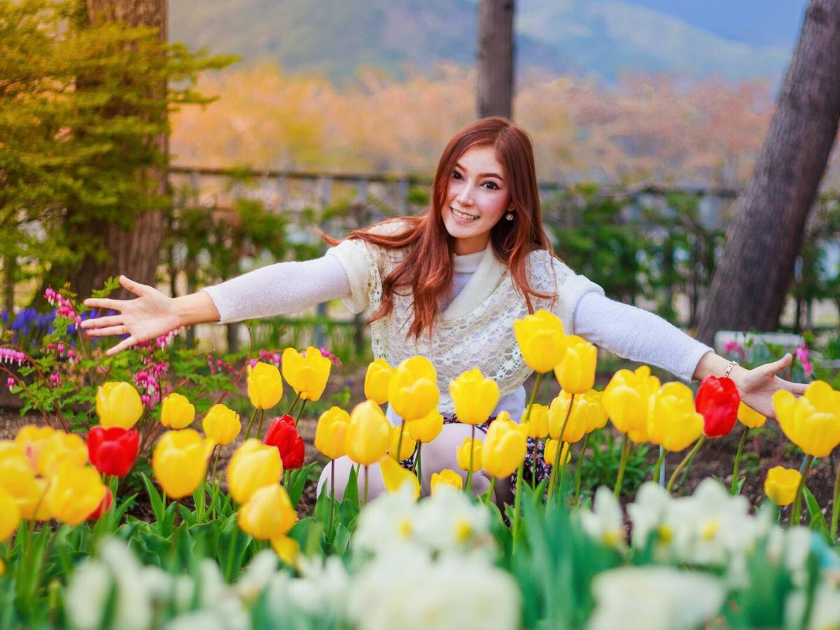 A woman in a garden with tulips.
