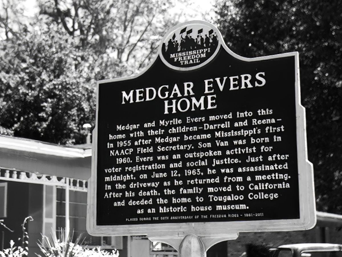 A black and white photo of a sign that says medgar evers home.