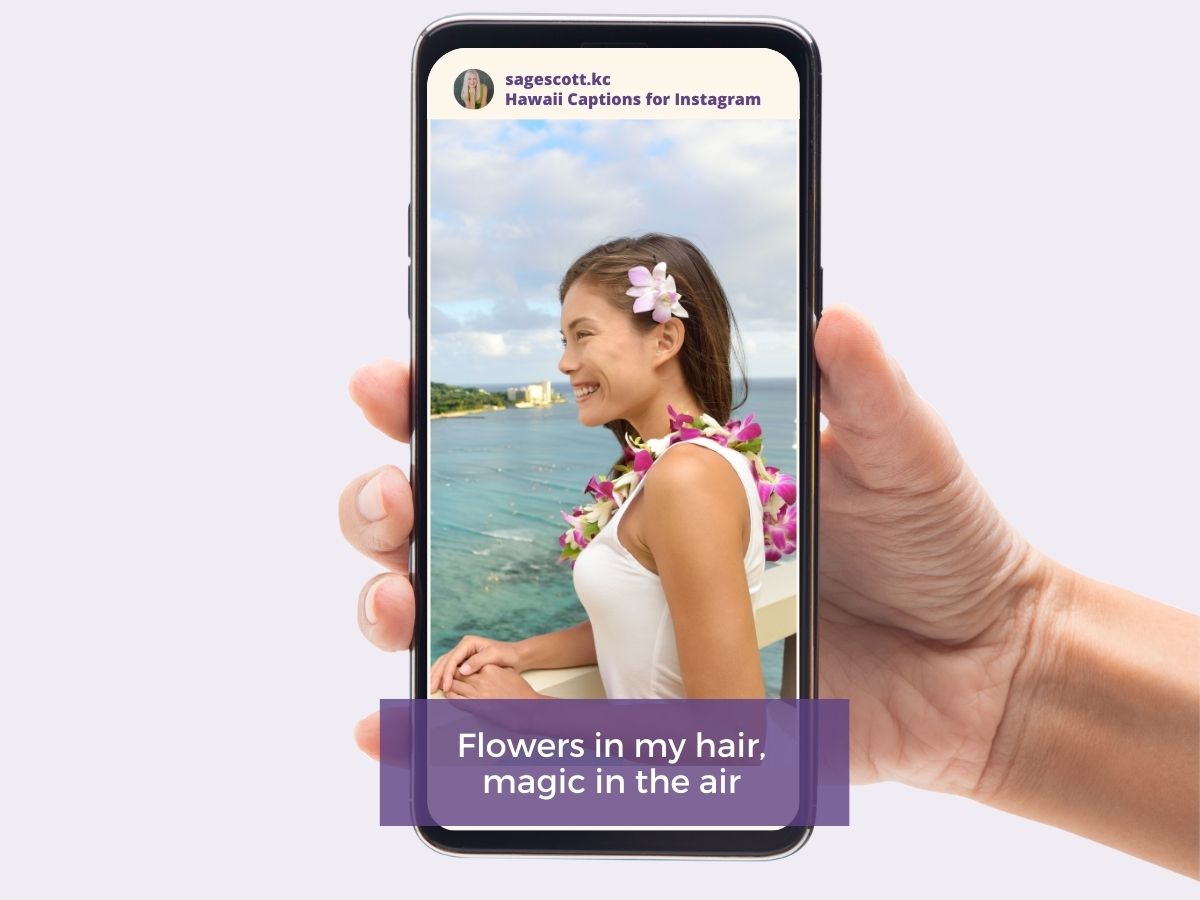 Hand holding a smartphone displaying a photo of a smiling woman with a flower in her hair, looking out at the sea, with a caption for social media.